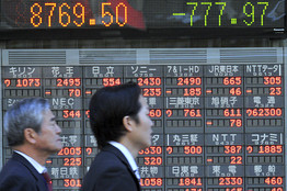 [Pedestrians walk beside an  electric market board in Tokyo, Thursday, Oct. 16, 2008.]