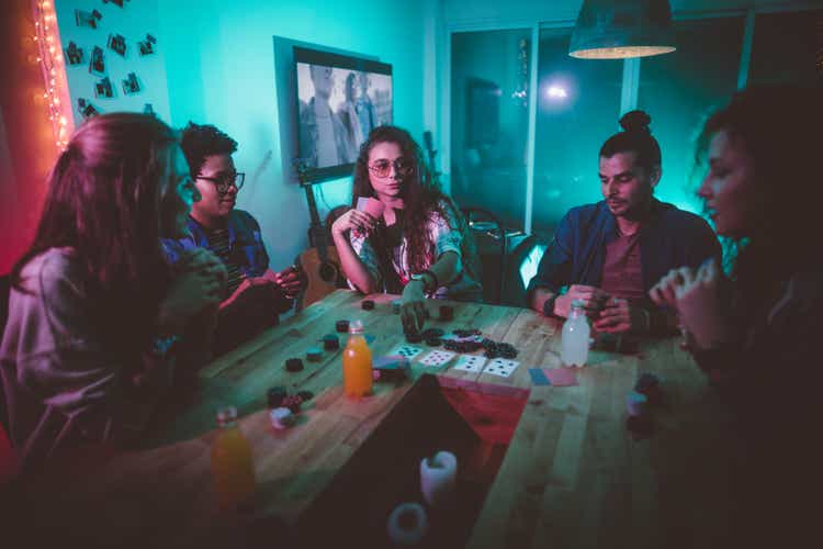 Multi-etnische hipster vrienden pokeren thuis
