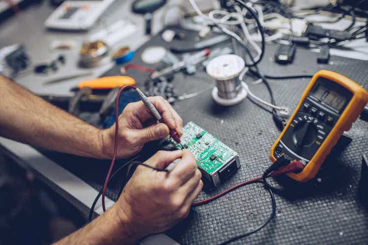 Repairman checking voltage with a digital multimeter