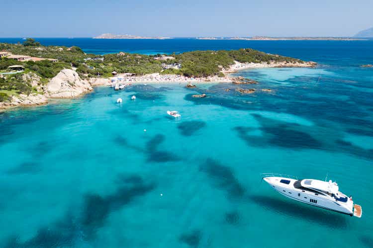 View from above, aerial picture of a yacht floating on the transparent and turquoise Mediterranean sea. Emerald Coast (Costa Smeralda) in Sardinia, Italy.