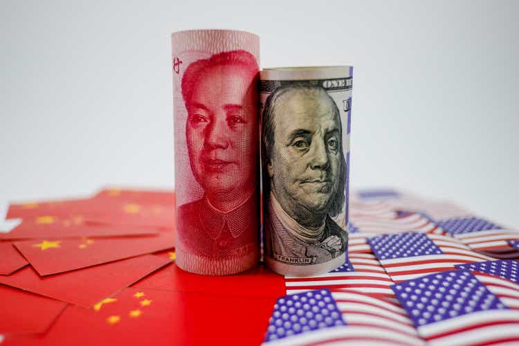 China yuan banknote on China flags and US dollar banknote on united states flags for trade war