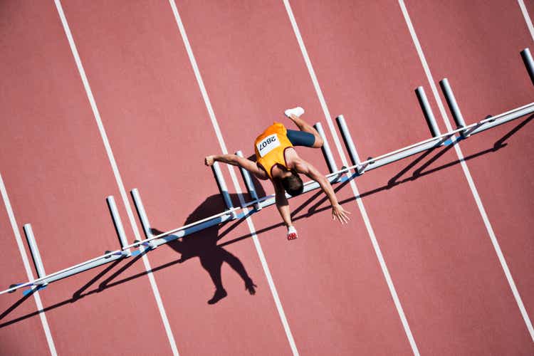 Runner jumping hurdles on track
