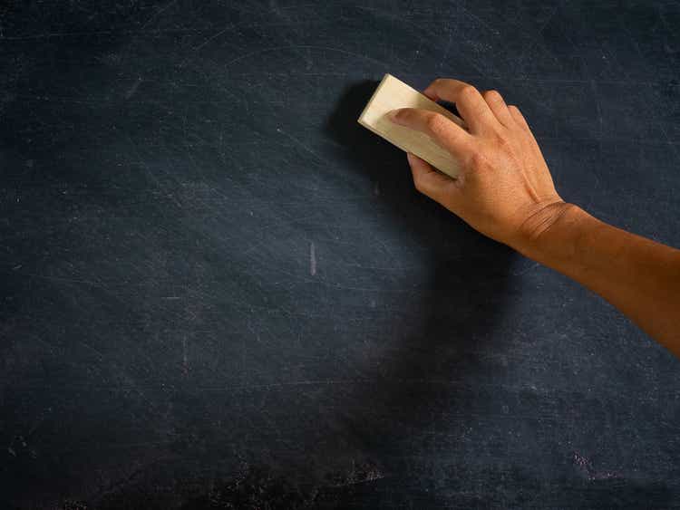 Hand holding brush eraser and blackboard.