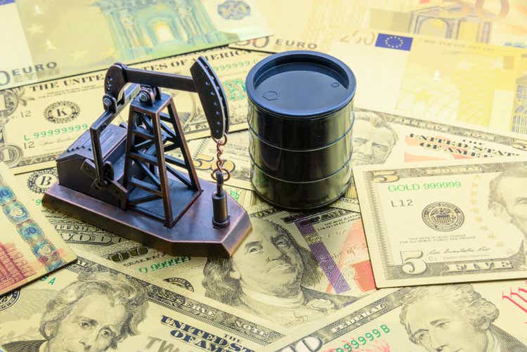 Petroleum, petrodollar and crude oil concept : Pump jack and a black barrel on US USD dollar notes, depicts the money received or earned from sales after investment in the development of oil industry.