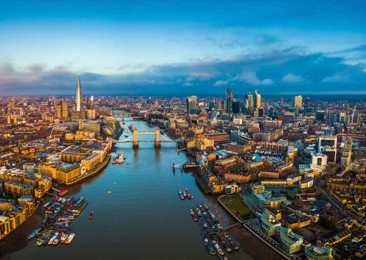 London, England - Panoramic aerial skyline view of London including Tower Bridge with red double-decker bus, Tower of London, skyscrapers of Bank District