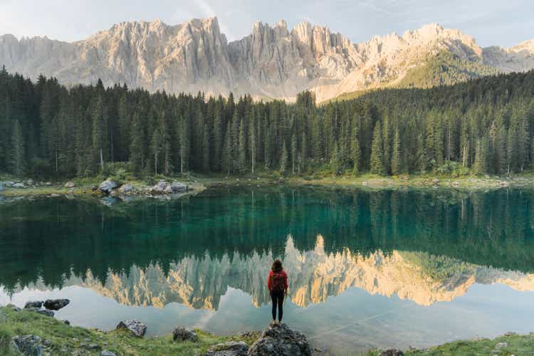 Woman standing and looking at Lago di Carezza in Dolomites