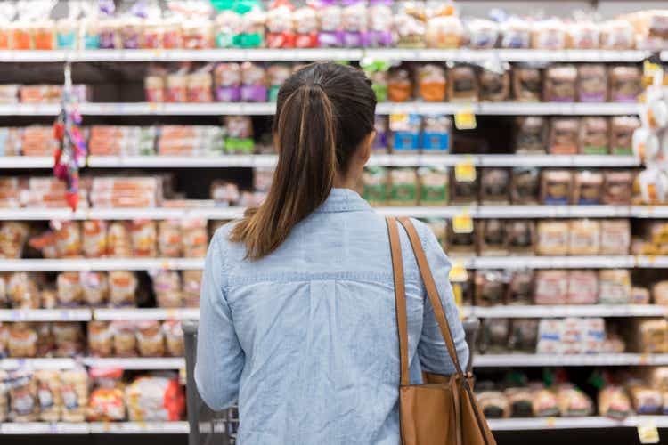 Unrecognizable woman is surprised when choosing grocery baguettes