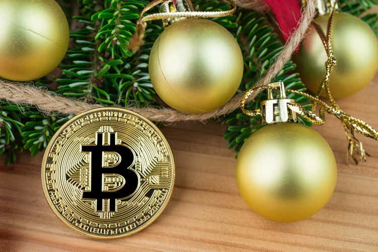 Christmas decoration - golden baubles, poinsettia, fir branches with Bitcoin.