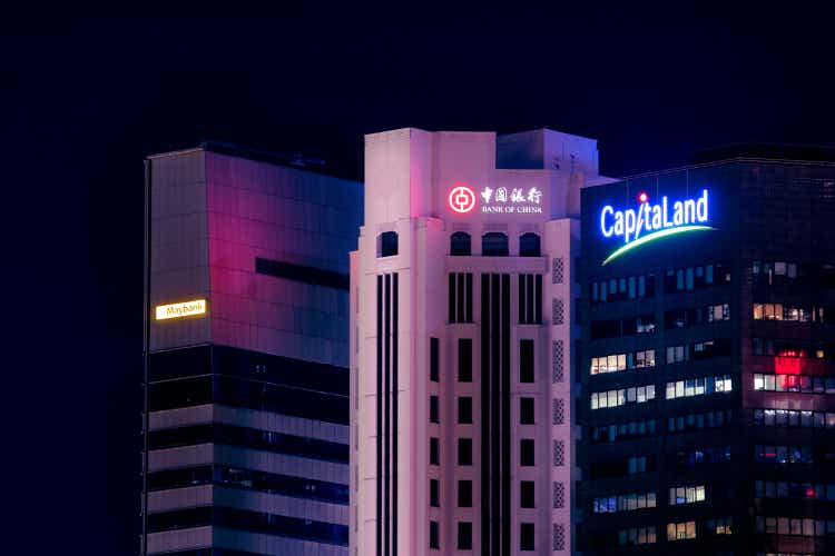 Close-up shot of Singapore"s Central Business District at night. The skyscrapers of three major banks, Maybank, Bank of China and CapitaLand are lighted by vivid, purple and blue colors.