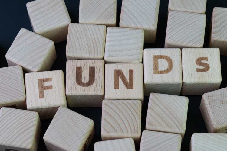 Mutual funds, investment asset selection by performance concept, cube wooden block with alphabet combine the word abbreviation FUNDs on black chalkboard background