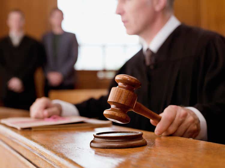 Judge holding hammer in courtroom