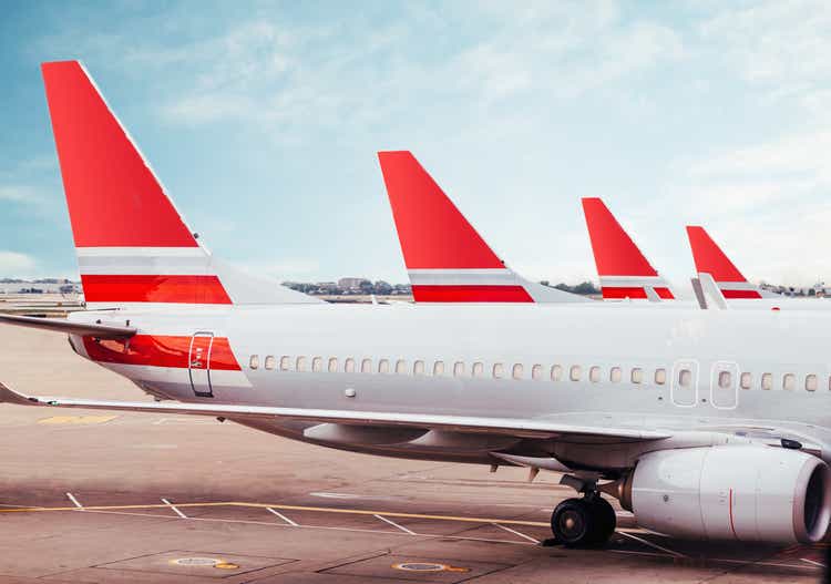 Row of plane fuselage tails on tarmac at airport