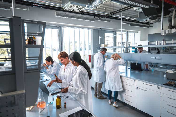 Researcher discussing with colleague in laboratory