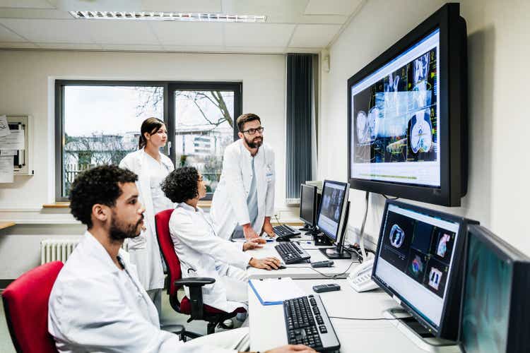 Group Of Research Doctors Looking At Patient Data