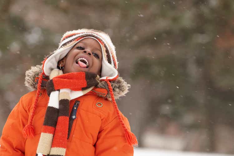 African American girl catching snowflakes on tongue