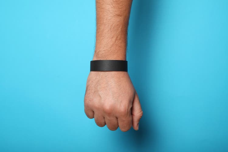 Black blank bracelet on hand. Music festival branding wristband, adhesive paper accessory for concert, event. mockup