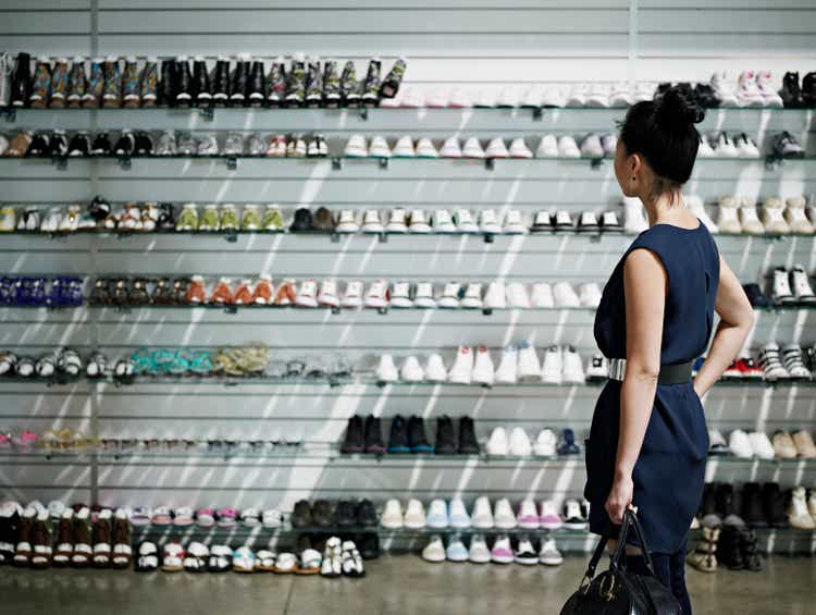 Woman shopping looking at shelves of shoes