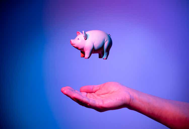 Piggy bank floating on hand