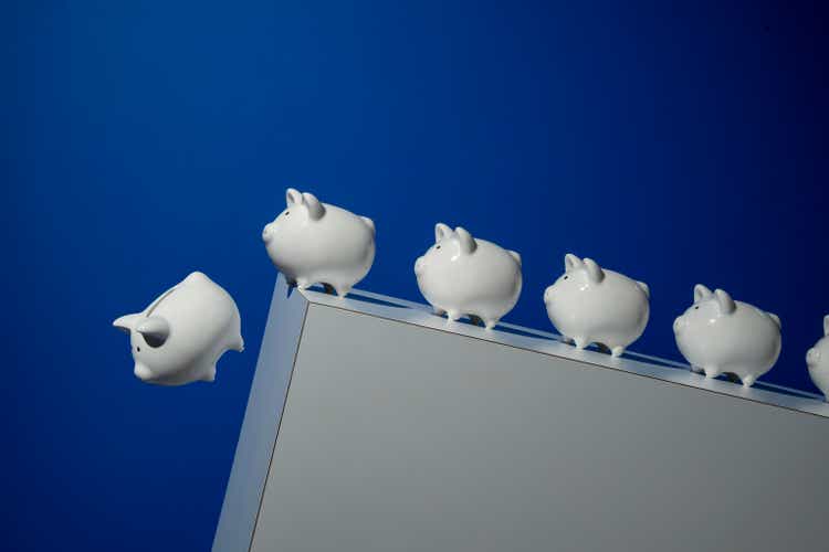 Piggy banks going over a cliff