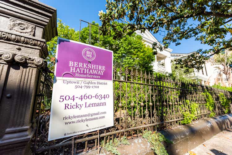 Old street historic Garden district in Louisiana famous town, city sidewalk, closeup of Berkshire Hathaway real estate sign on fence