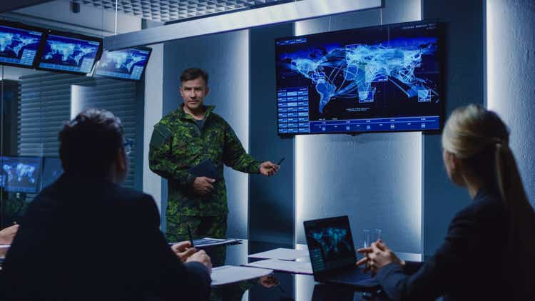 Hombre militar de alto rango tiene un informe a un equipo de agentes del gobierno y los políticos, muestra imágenes de vigilancia vía satélite.