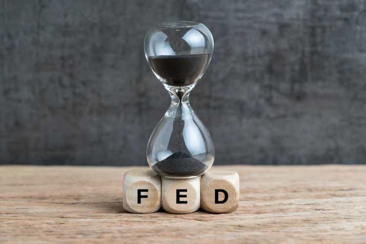 Federal Reserve Update: Fed Reports Third Consecutive Quarterly Loss - Expect More Losses Ahead 1 Federal Reserve, FED target and speed to raise interest rate concept, hourglass or sandglass on cube wooden block with alphabet building acronym FED on wooden table with dark background