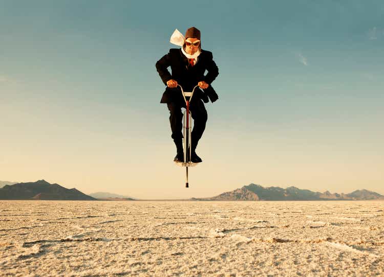 Businessman on Pogo Stick in Desert