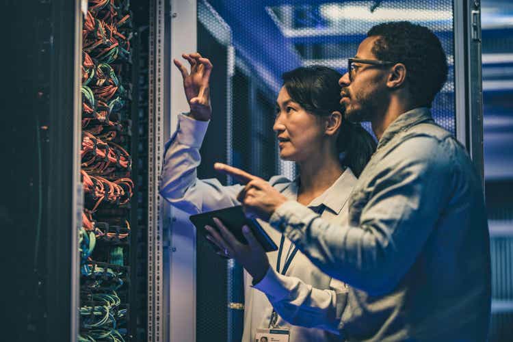 Female Asian IT technician explaining network connection to a novice engineer