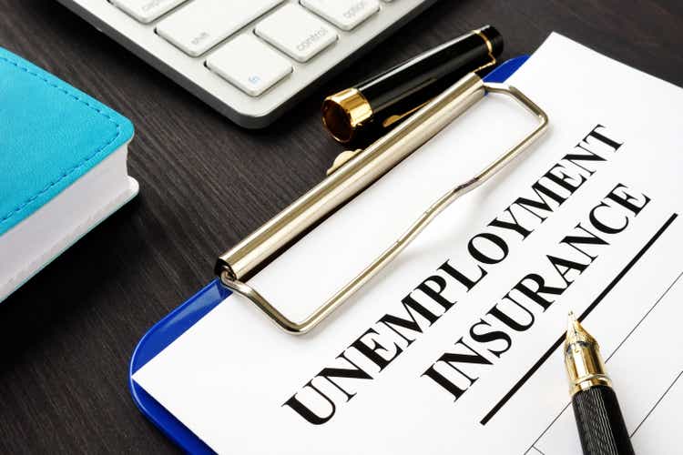 Unemployment insurance form and clipboard on a desk.