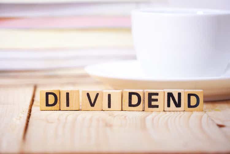 Text " DIVIDEND "on cube dice on working table , finance concept.