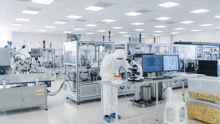 Shot of Sterile Pharmaceutical Manufacturing Laboratory where Scientists in Protective Coverall"s Do Research, Quality Control and Work on the Discovery of new Medicine.