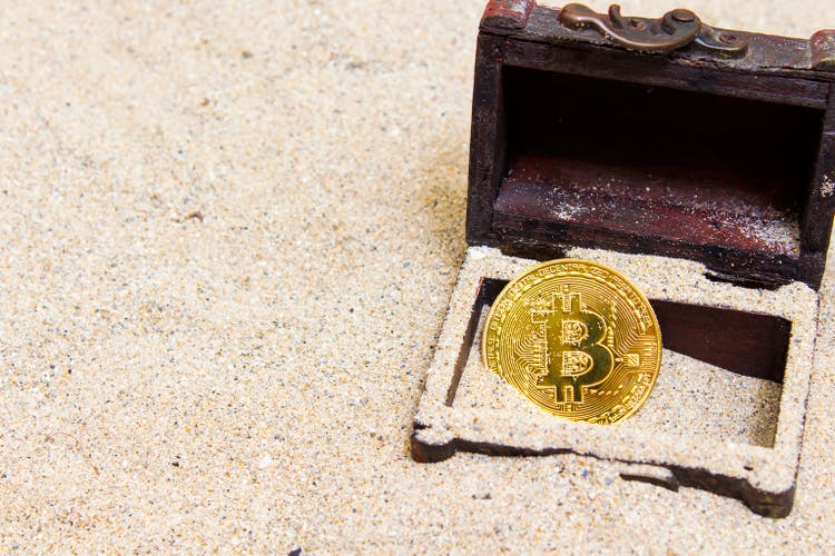 Mascara, Algeria - December 25, 2018: founding Gold bitcoins on sand. Bitcoins and New Virtual money concept