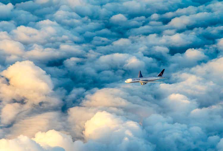 United airlines aircraft flies in the dark clouds with sunlight at the cockpit