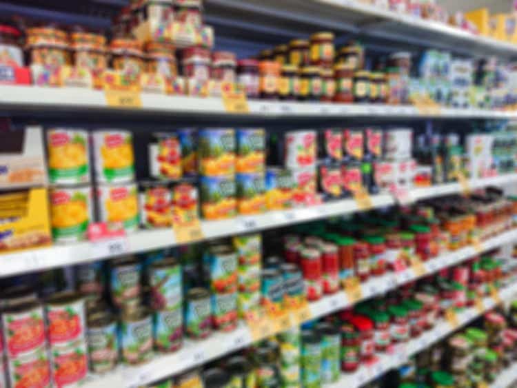 Blurred abstract image. Goods on the shelf of a grocery store. Canned vegetables and fruit