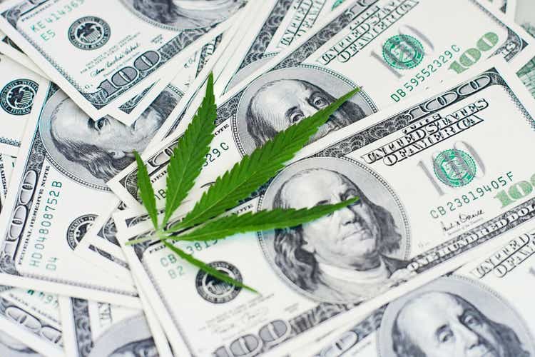 Cannabis leaf with money. Marijuana on background dollar. Concept legalization of the drug business. Thematic photos pharmaceutical or medical industries.