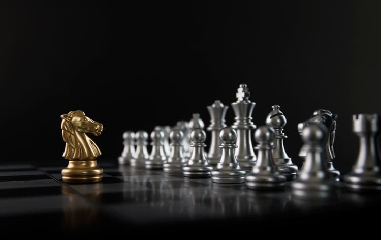 Chess (knight confront opponent or competitor) on black background. Strategy, market share, business investment, business competition, opportunity, brave, fearless, dare, fight or front line concept.