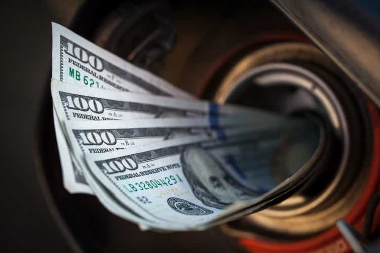 Gas Prices Concept: Gas tank eats money