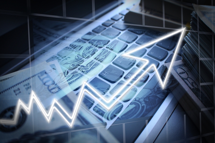 Day Trader With Stacks Of Cash On Laptop Keyboard