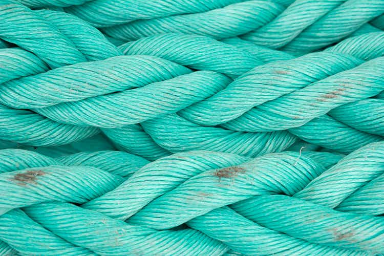 Nautical background. Old blue frayed ship rope close-up.