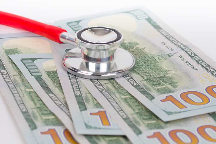 100 dollars banknotes and stethoscope, financial crisis concept