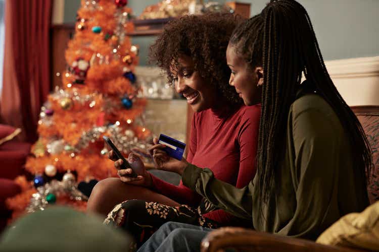 Young women ordering Christmas gifts online with creditcard