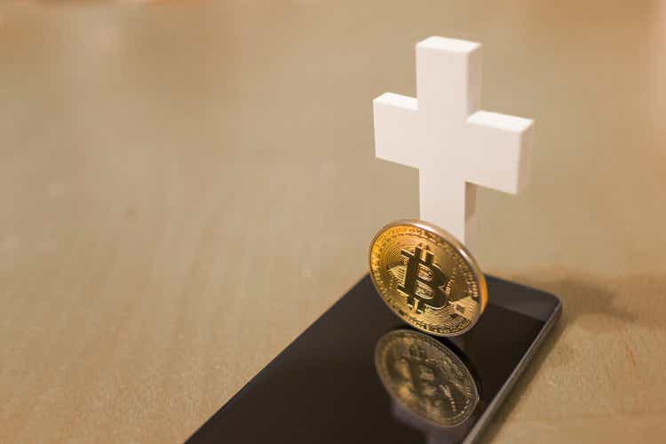 Bitcoin with smartphone and white cross