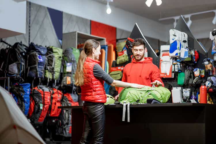 Woman with salesman at the counter of the sports store