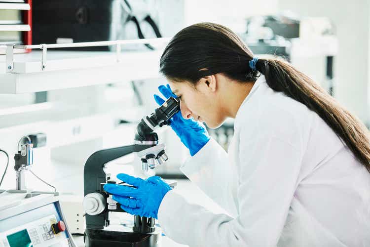 Female scientist using microscope in laboratory