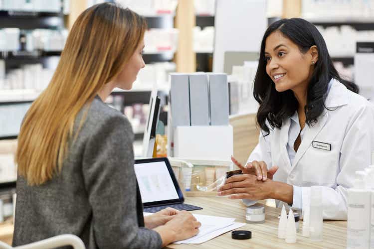 Pharmacist with businesswoman examining samples