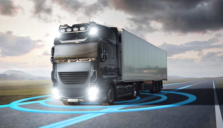 Truck with visualized sensor graphics driving on a highway