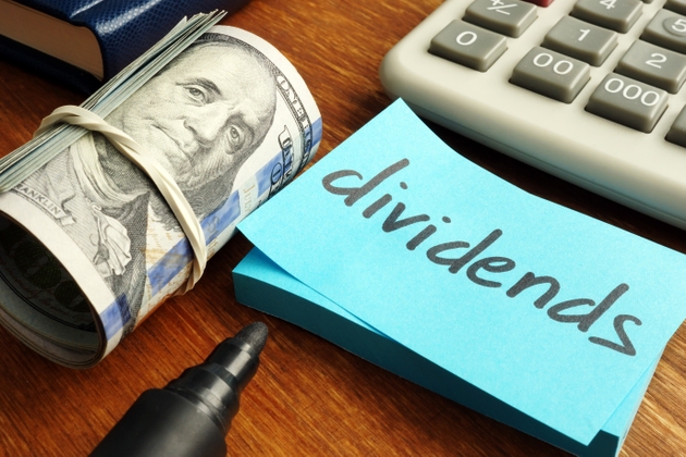 Dividends concept. Stack of dollars and calculator.