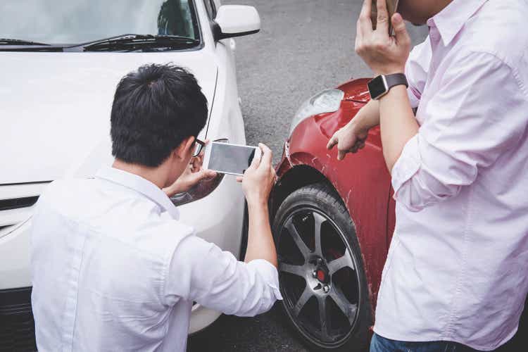 Two drivers man arguing after a car traffic accident collision and making phone call to Insurance Agent and take a photo, Traffic Accident and insurance concept
