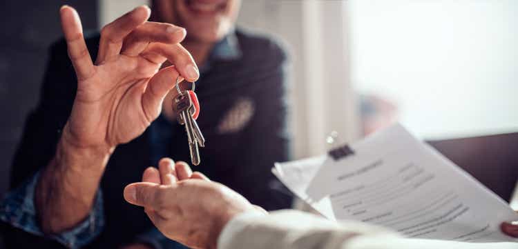 Real estate agent passing keys to his client