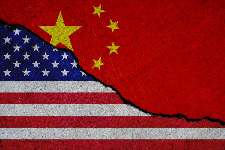 united states and china flags painted over cracked concrete wall